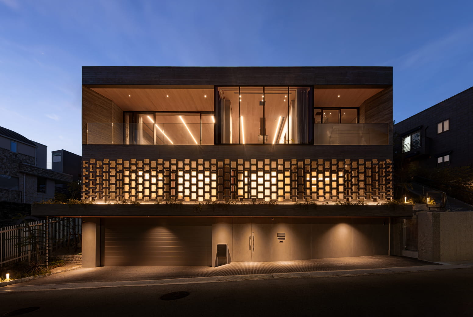 2階の大きなガラス窓からは室内の照明が見え、温かみのある木材天井が強調されている