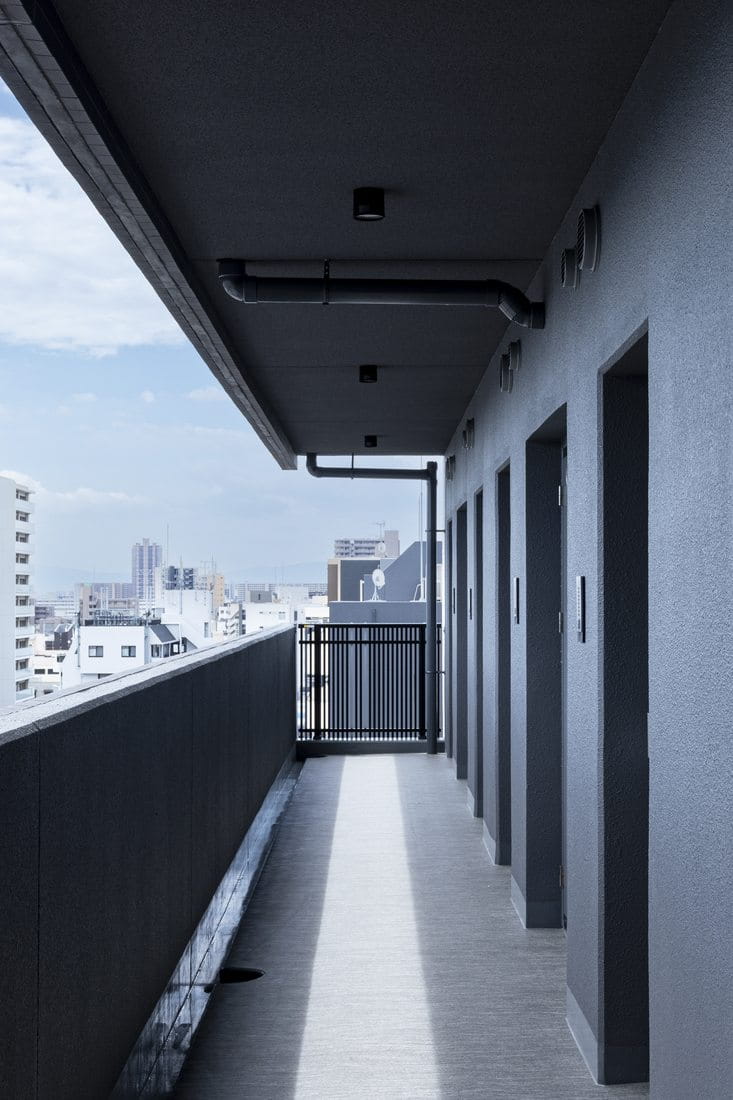 外気に開かれた共用廊下。奥に街並みが広がる